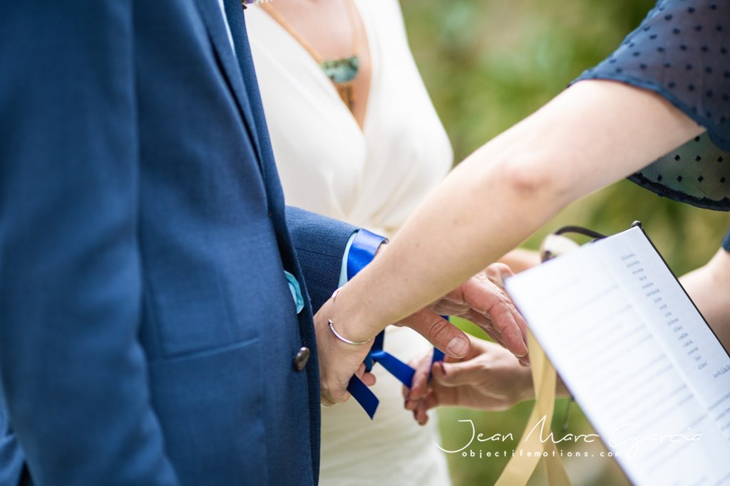 Focus sur les mains d'un couple heureux lors d'une cérémonie laïque, à Toulouse en Occitanie lors du rituel des rubans