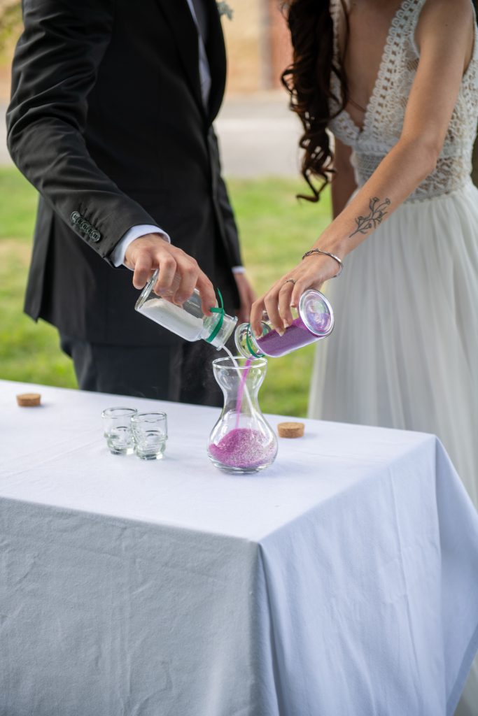 Focus sur les mains d'un couple heureux lors d'une cérémonie laïque, à Toulouse en Occitanie lors du rituel du sable