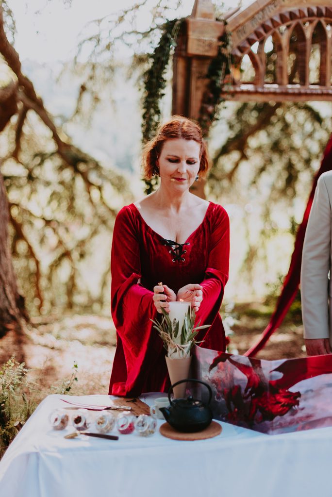 Aude, officiante de la plume de vos envie, fait un hommage à l'aide d'une bougie, lors d'un mariage Donjon et Dragon, au domaine de Carlabas, près d'Agen en Occitanie.